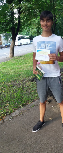 me holding the diploma and a book as gift